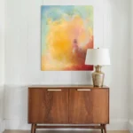 abstraktní žluto-červeno-modrý obraz pověšený nad komodou