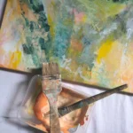 kousek abstraktního obrazu a štetec s barvou