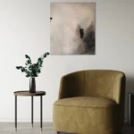 šedo-černý abstraktní obraz nad křeslem a stolkem