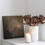 hnědý abstraktní obraz váza a svíčka