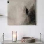 šedo-černý abstraktní obraz nad policemi