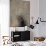 šedo-černý abstraktní obraz nad černou komodou