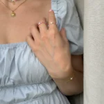 detail ženské ruky s prstýnky, položené na rukávu ženy