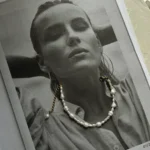 A4 stránka černobílé fotky s ženou a na tom náramek z perel